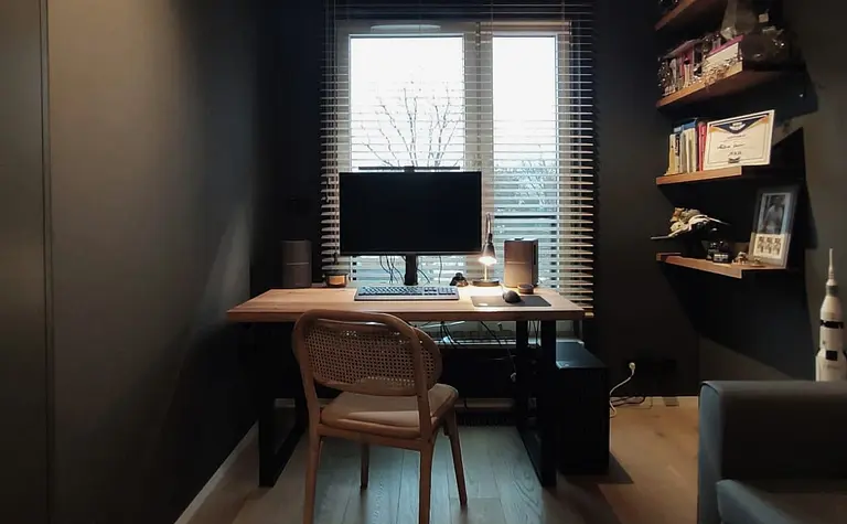 Wnętrze gabinetu z biurkiem, komputerem i minimalistycznymi akcentami w stylu quiet luxury.
