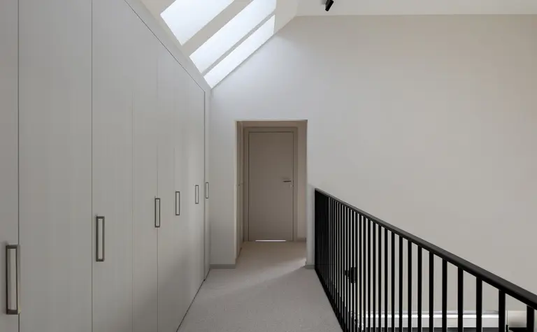 Korytarz z białymi szafkami, szarym podłogą, nowoczesny i współczesny design.