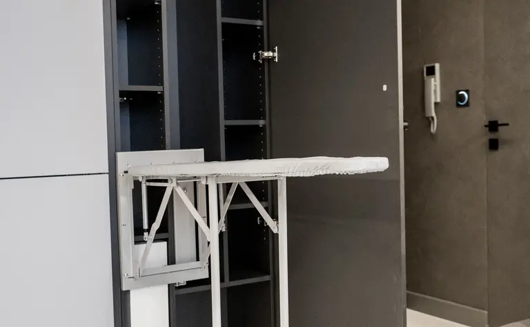 Nowoczesne wnętrze z szarymi meblami i składanym stołem, idealne do małych przestrzeni.