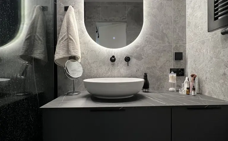Nowoczesna łazienka w soft minimalizmie z szarymi płytkami i eleganckimi akcentami.