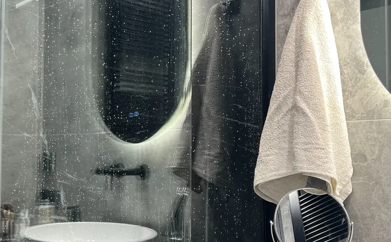 Nowoczesna łazienka w stylu soft minimalizm z szarym blatem i okrągłą umywalką.