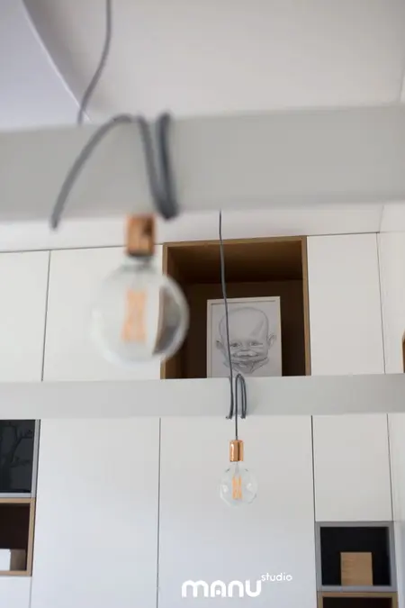 Wnętrze z industrialnym i minimalistycznym stylem, białe meble, nowoczesne oświetlenie.