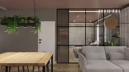 Wnętrze salonu z industrialnym stylem, szare ściany, drewniany stół i rośliny.