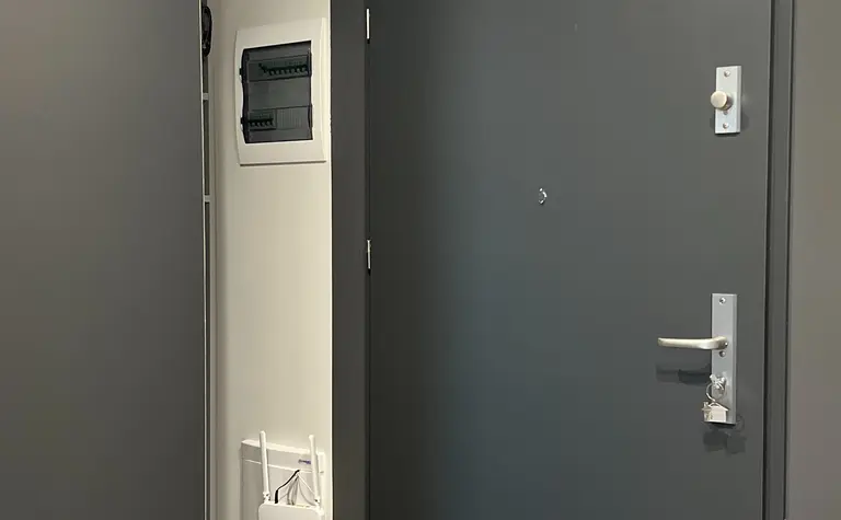 Nowoczesny przedpokój w soft minimalizmie z szarymi ścianami i współczesnymi detalami.