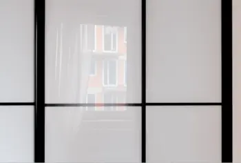 Przeszklona ściana z czarnymi detalami w minimalistycznym wnętrzu