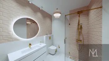 Nowoczesna łazienka z białą umywalką, złotymi elementami i minimalistycznym designem.
