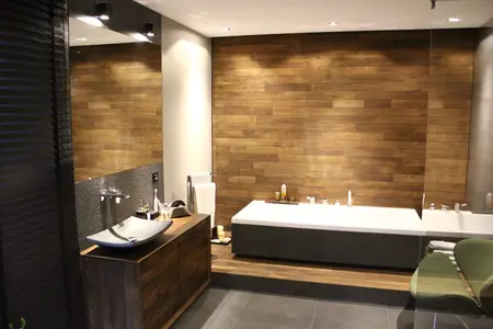 Nowoczesna łazienka z drewnianymi elementami, minimalistycznym designem i eleganckimi akcesoriami.