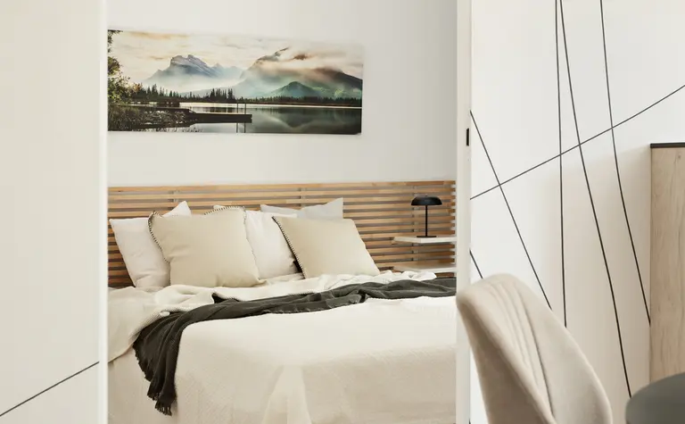 Wnętrze sypialni z minimalistycznym designem, nowoczesne meble i spokojna kolorystyka.