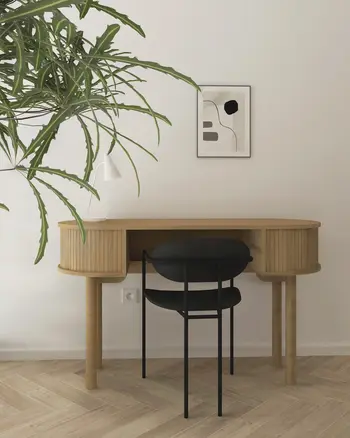 Minimalistyczne biuro w stylu japandi z drewnianym biurkiem i rośliną.