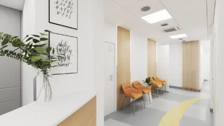 Recepcja w minimalistycznym stylu minimaluxe z pomarańczowymi krzesłami i rośliną