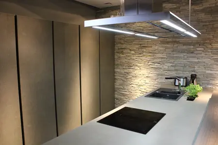 Kuchnia minimalistyczna z szarymi ścianami i nowoczesnym blatem