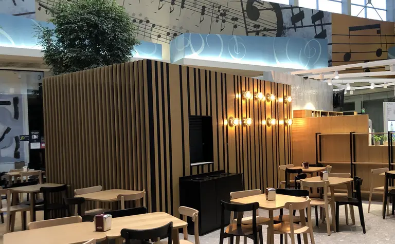 Kawiarnia w stylu japandi z minimalistycznymi meblami i roślinnością.