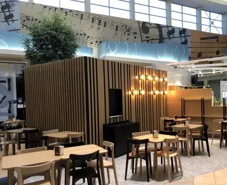Kawiarnia w stylu japandi z minimalistycznymi meblami i roślinnością.