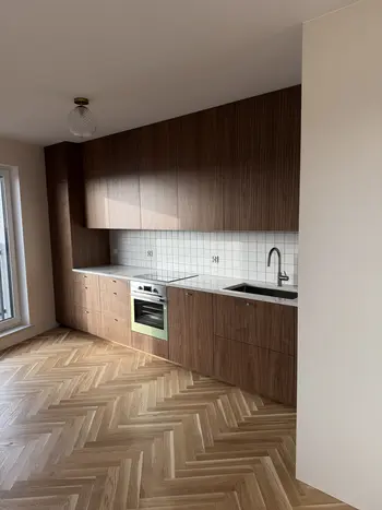 Kuchnia w stylu boho z drewnianymi meblami i białymi kafelkami.