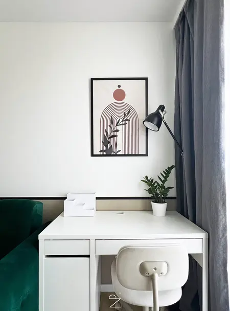 Wnętrze biura z minimalistycznym wystrojem, z białym biurkiem oraz zieloną sofą, w stylu quiet luxury.