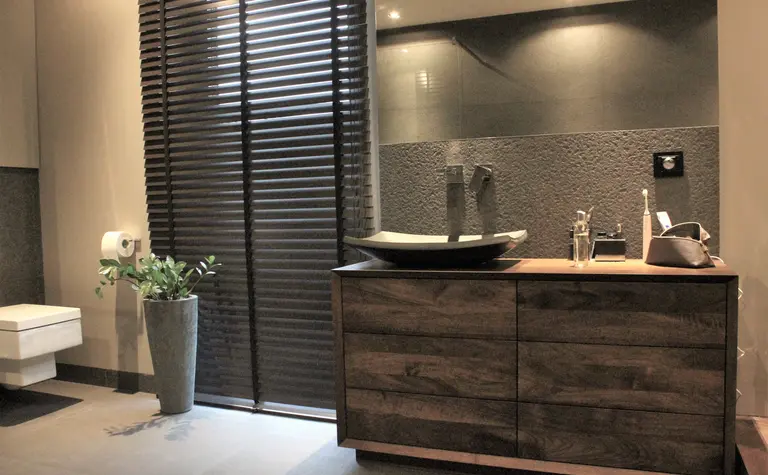 Nowoczesna łazienka z drewnianą szafką, minimalistycznymi akcentami i elegancką umywalką.