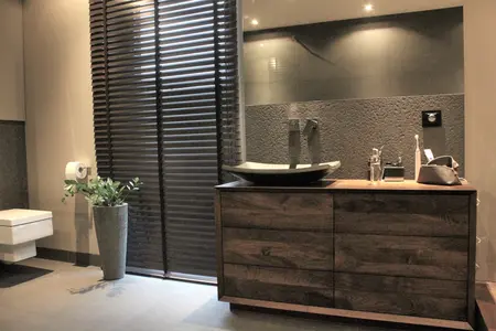 Nowoczesna łazienka z drewnianą szafką, minimalistycznymi akcentami i elegancką umywalką.