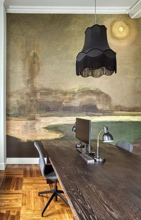 Wnętrze biura z eklektycznym stylem, nowoczesnym biurkiem oraz vintage lampą.