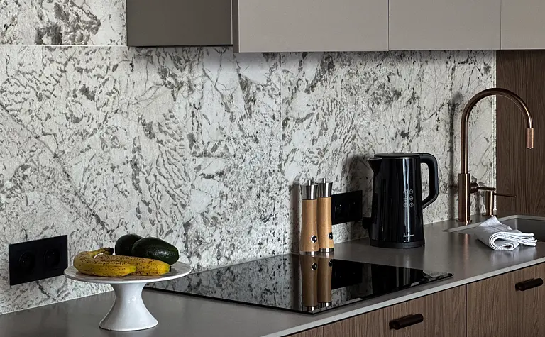 Wnętrze nowoczesnej kuchni z marmurowym blatem i drewnianymi detalami