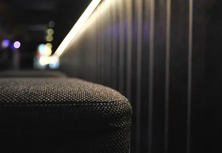 Wnętrze z industrialnym i nowoczesnym stylem, czarna sofa i drewniana ściana.