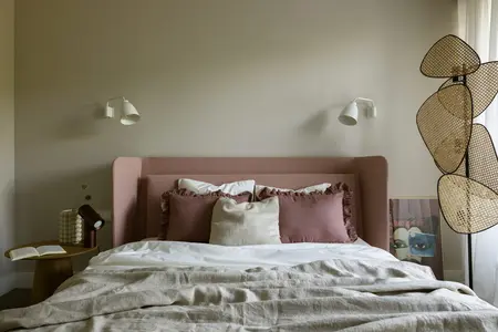 Wnętrze sypialni z różowymi akcentami, minimalistycznym oświetleniem i nowoczesnymi meblami.