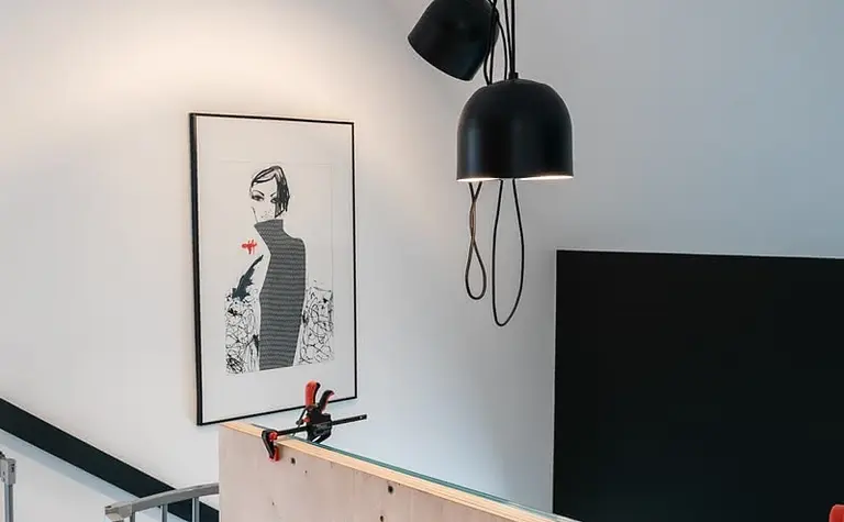 Wnętrze z industrialnymi lampami i minimalistycznym panelem na ścianie, styl skandynawski.