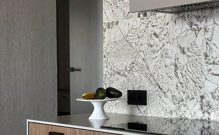 Nowoczesna kuchnia z drewnianymi meblami i szarym blatem, współczesne akcenty.