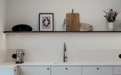 Wnętrze kuchni w stylu art deco, boho i eklektycznym z białymi meblami.