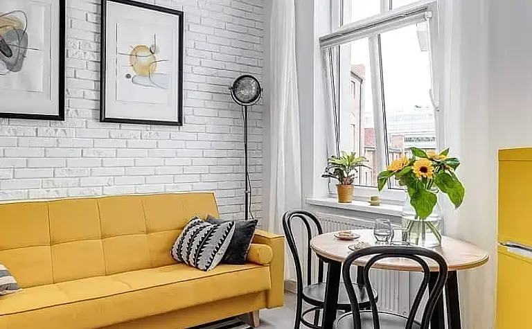 Nowoczesny salon w stylu minimalistycznym z szarymi sofami i drewnianymi akcentami.