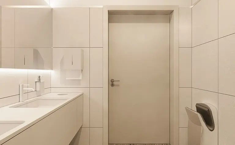 Minimalistyczna łazienka z nowoczesną umywalką i delikatnym oświetleniem.