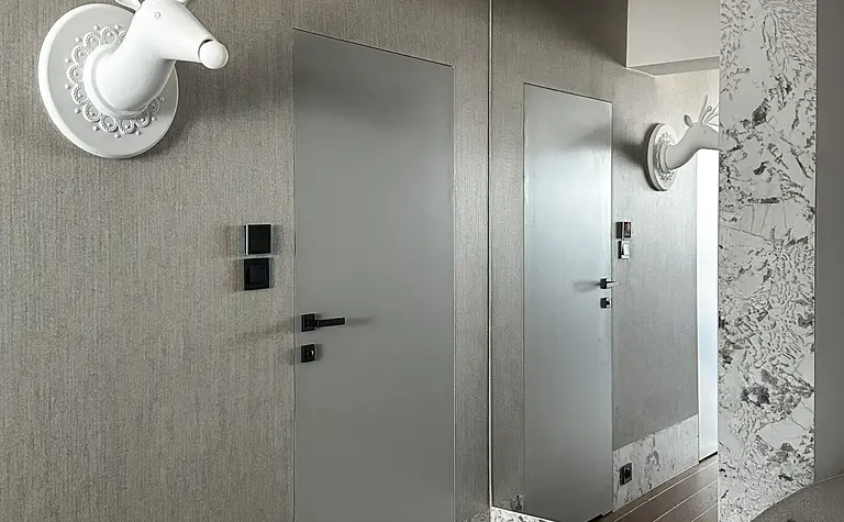 Przedpokój z szarymi ścianami, białym jeleniem i lustrem.