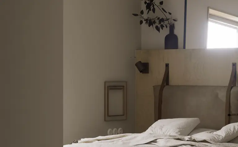 Sypialnia z eklektycznym i rustykalnym stylem, drewniane elementy, biała pościel.
