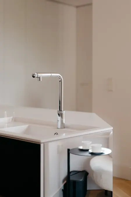 Kuchnia w stylu minimalistycznym z białym blatem i czarnymi elementami.