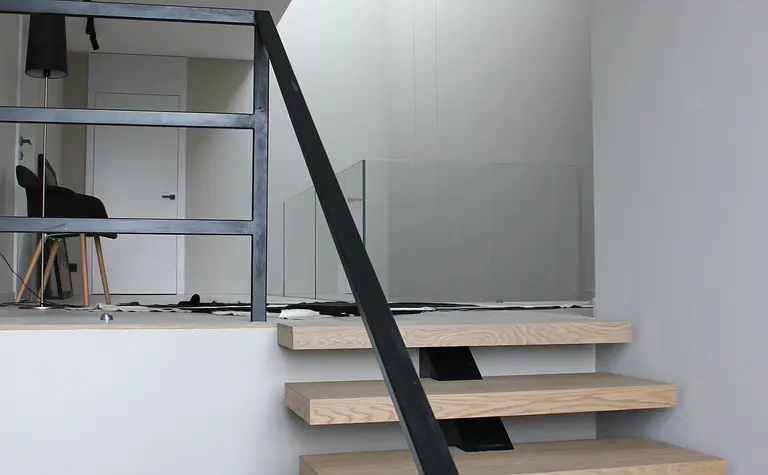 Minimalistyczne wnętrze z drewnianymi schodami i nowoczesnymi akcentami