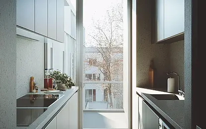 Nowoczesna, wąska kuchnia w minimalistycznym stylu z dużym oknem, jasnymi szafkami, blatem kuchennym oraz roślinami na parapecie