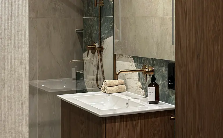 Nowoczesna łazienka z drewnianą szafką i marmurowymi detalami, styl współczesny.