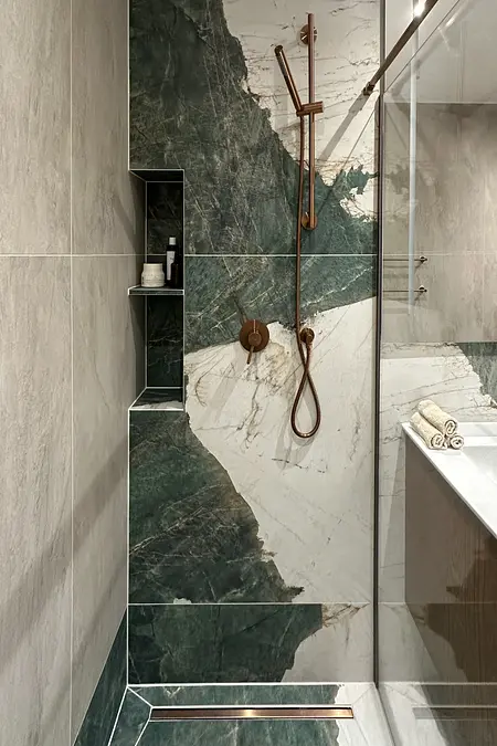 Nowoczesna łazienka z zielonymi płytkami i złotymi detalami.