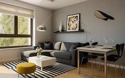 Wnętrze salonu w stylu eklektycznym z szarymi meblami, żółtym pufem i nowoczesną lampą.