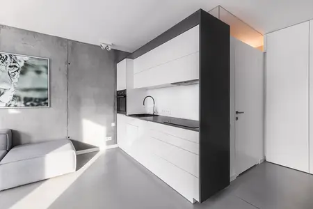 Wnętrze kuchni w stylu industrialnym i minimalistycznym z białymi meblami.