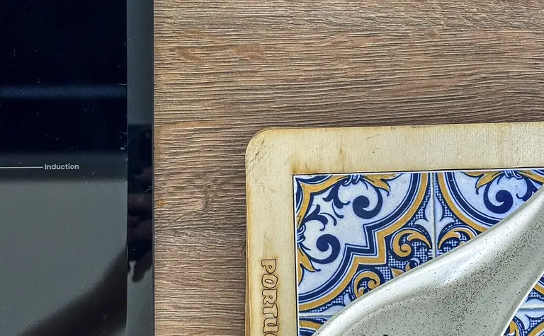 Wnętrze kuchni z drewnianym blatem i ceramicznymi naczyniami w stylu boho i współczesnym.