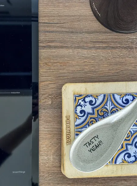 Wnętrze kuchni z drewnianym blatem i ceramicznymi naczyniami w stylu boho i współczesnym.