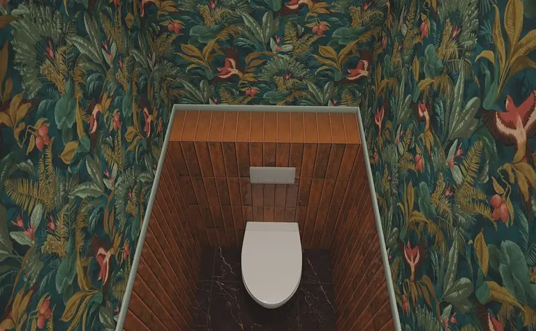 Toaleta z eklektycznym wzorem roślinnym i drewnianymi elementami.
