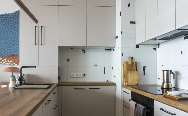 Kuchnia w stylu boho i współczesnym z białymi meblami i drewnianymi akcentami.