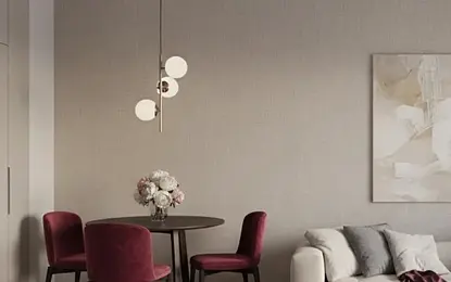 Wnętrze jadalni z okrągłym stołem, bordowymi krzesłami i nowoczesnym oświetleniem w stylu minimaluxe.