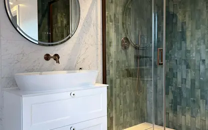 Nowoczesna łazienka z białą umywalką, szklanym prysznicem i zieloną mozaiką w stylu glamour.