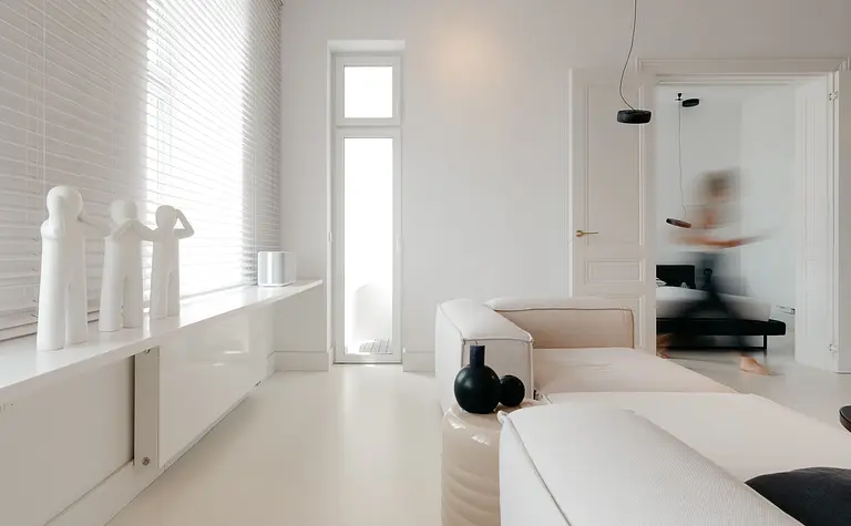 Nowoczesne wnętrze salonu w stylu eklektycznym i minimalistycznym z białymi meblami.