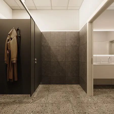 Wnętrze minimalistycznej łazienki z szarymi płytkami i nowoczesną armaturą.