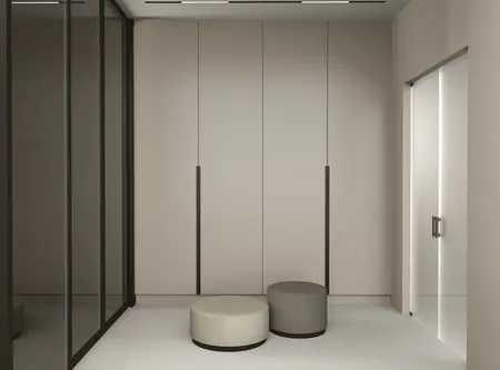 Nowoczesny przedpokój z szafą, szarym i beżowym siedziskiem, w stylu quiet luxury.