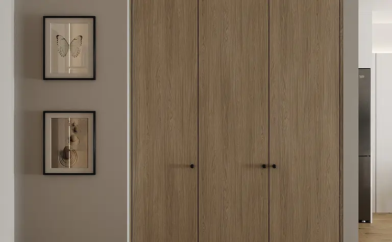 Wnętrze garderoby z drewnianymi szafami, minimalistycznymi obrazami i industrialnym stylem.