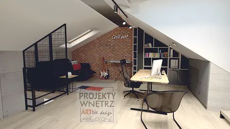 Poddasze w stylu industrialnym z biurkiem i sofą